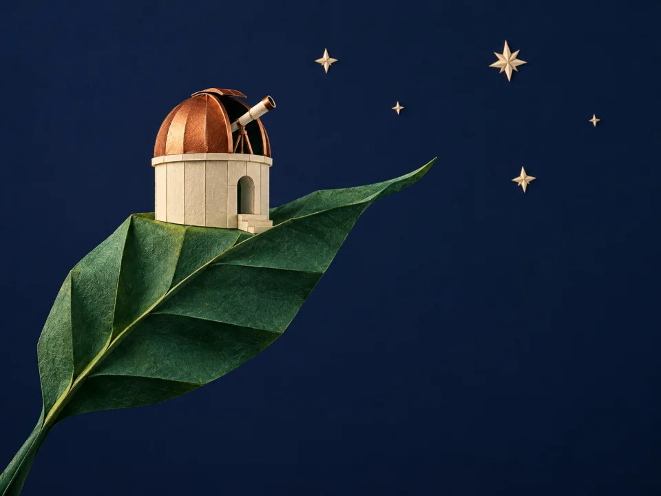 Copper-domed paper observatory supported by an emerald folded leaf
